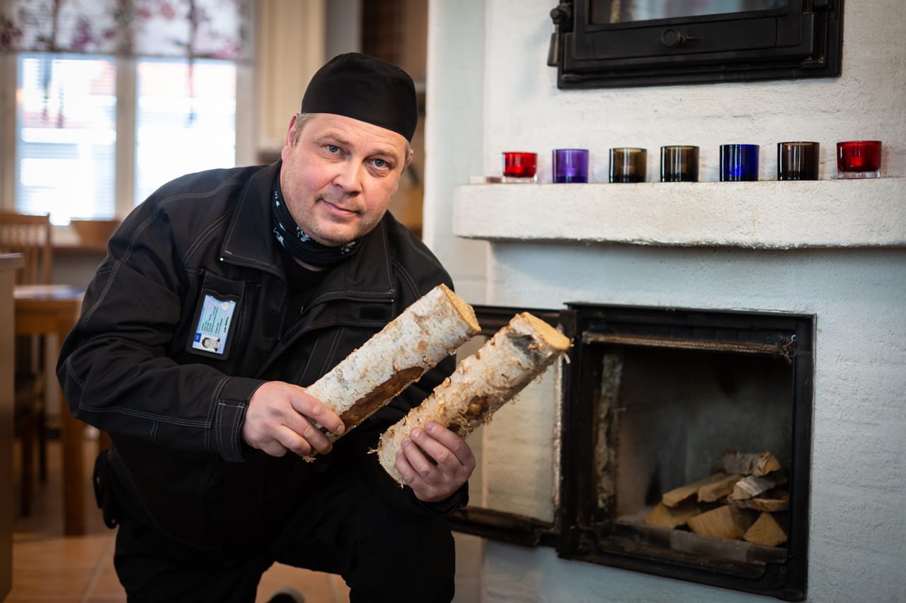 Nuohooja koivuhalkojen kanssa takan vieressä — ammattimainen palvelu